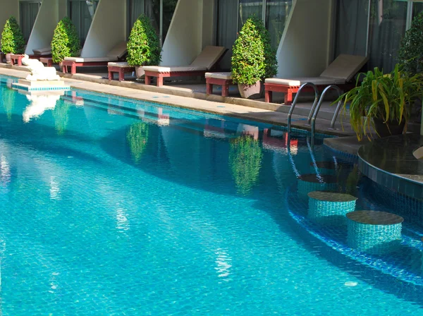 Blue water in hotel swimming pool with bar