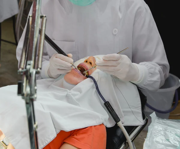 The doctor cleaning the teeth patient with ultrasonic tool
