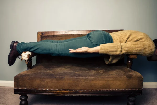 Young man in plank position on old sofa