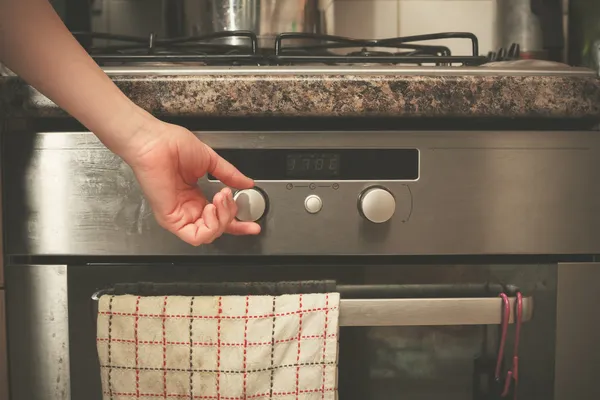 Hand turning knob on stove