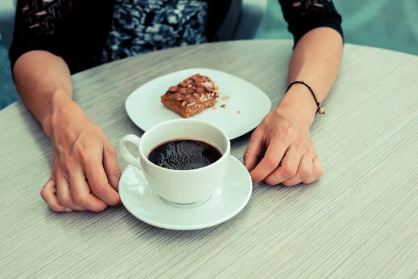 Young woman having coffee and cake