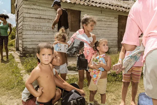 Local Cuban village people and kids holding a cloth and goods
