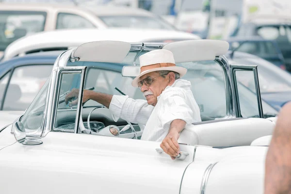 Wealthy man getting out from his luxury car on old Havana street