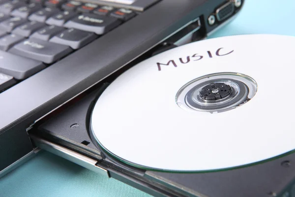 Closeup image of a laptop and a CD or DVD disc