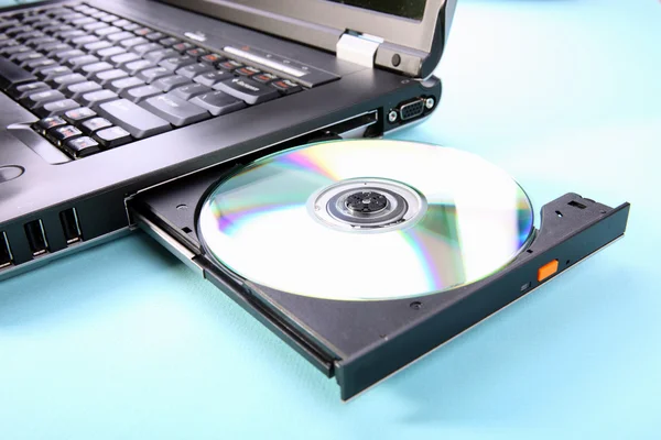 Closeup image of a laptop and a CD or DVD disc