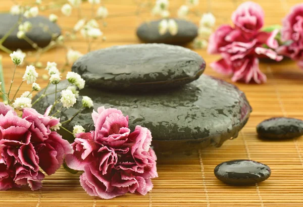 Pink flowers with sea stone in the massage parlor
