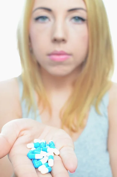 Young woman taking temperature and pills