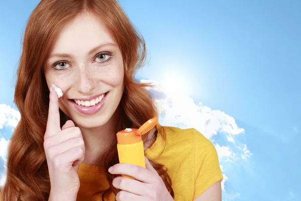 Happy woman uses sun lotion