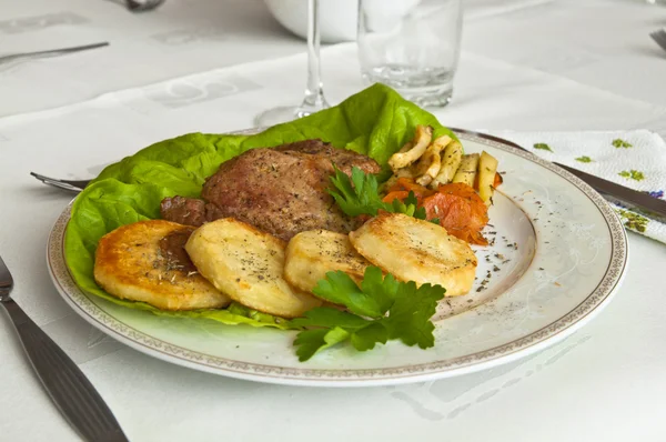 Tasty dinner - roast veal with fried potatoes and vegetables