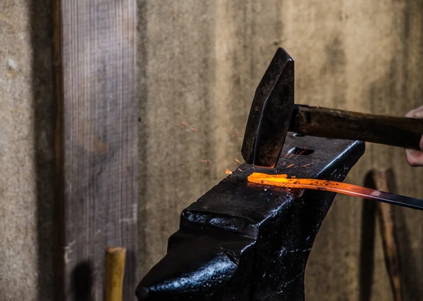 Hot iron strike with sparks by blacksmith