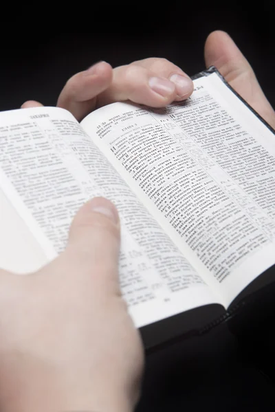 Closeup of the hands of a man holding russian bible