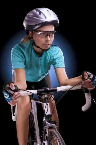 Female athlete riding her race bike isolated over black