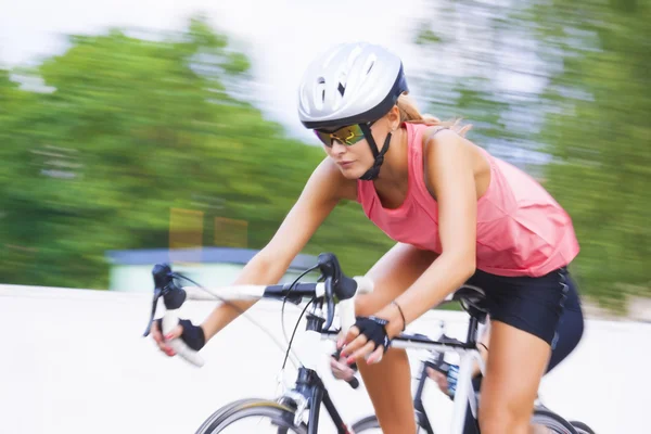Female athlete riding bike outdoors