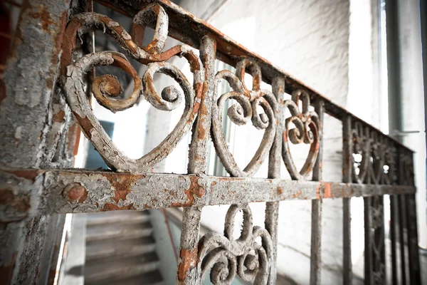 An old rusty wrought-iron railing