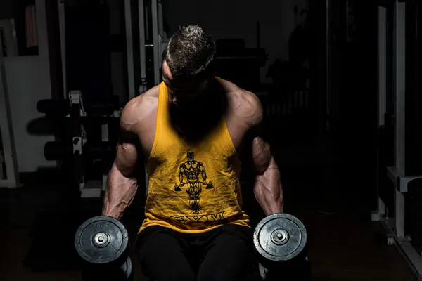 Fitness trainer posing with dumbbells