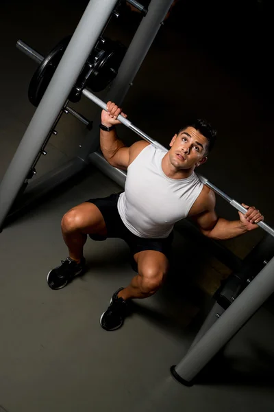 Young man exercising with barbell Squats