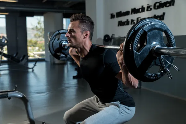 Fitness Trainer Doing Squats With Barbells