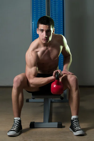 Teenage Boy Exercise With Kettle Bell Biceps