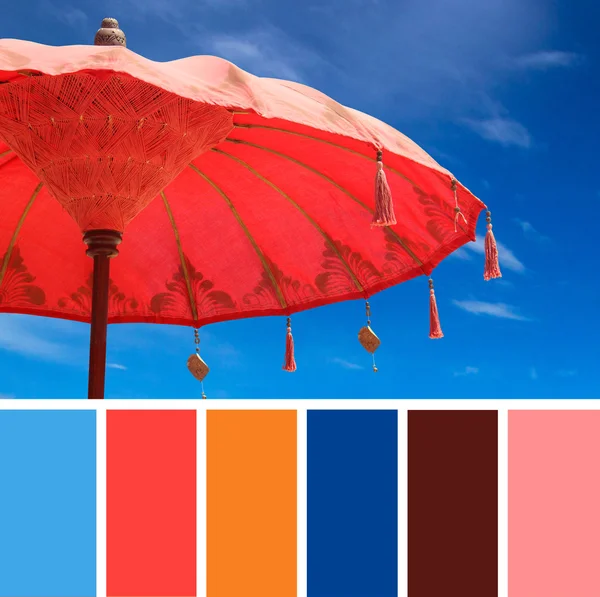 Orange beach umbrella umbrella on sky background , color palette swatches.