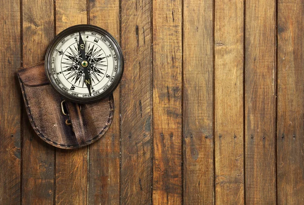 Old compass on wooden background with space for text