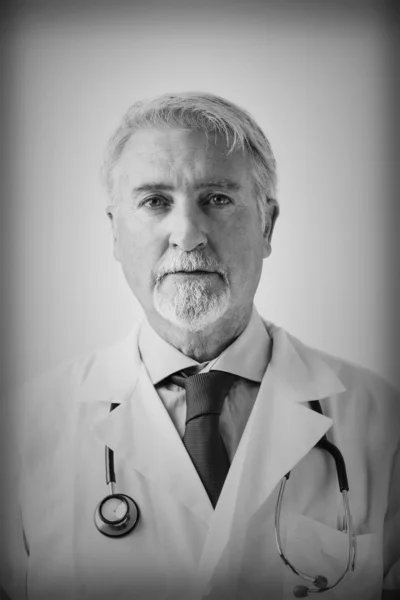 Portrait of a senior doctor against white background
