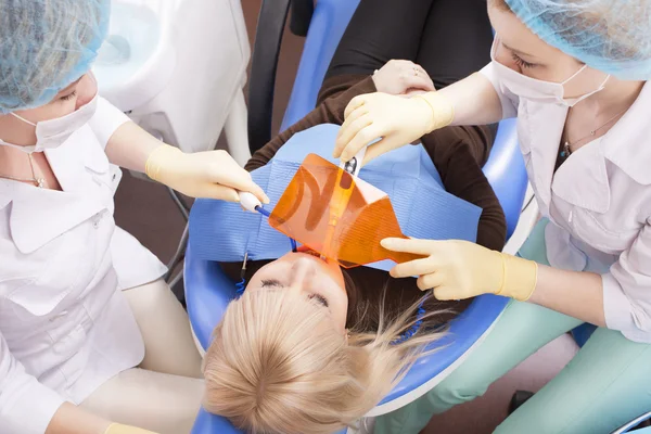 Dentist woman with assistant treating teeth