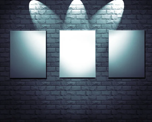 Blank frames on stone wall illuminated spotlights