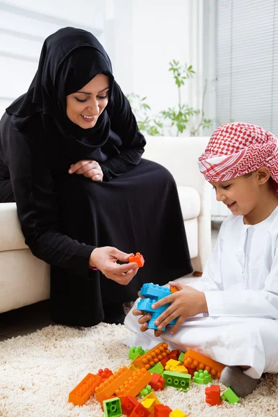 Arabic mother and son playing with toys