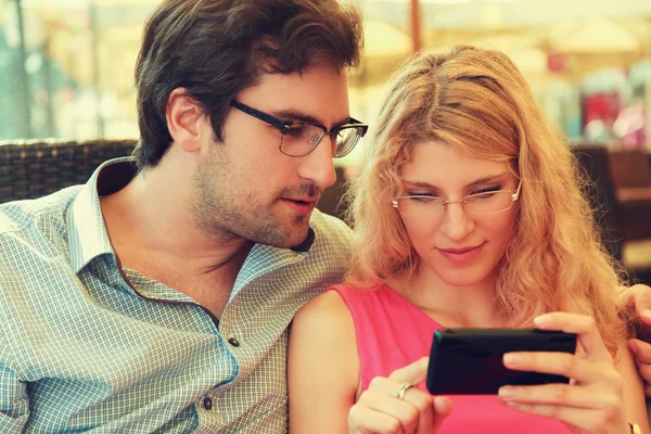 Couple in cafe using smart phone