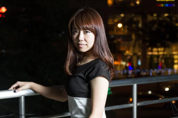 Attractive Asian Woman in front of Mall with bright LIghts