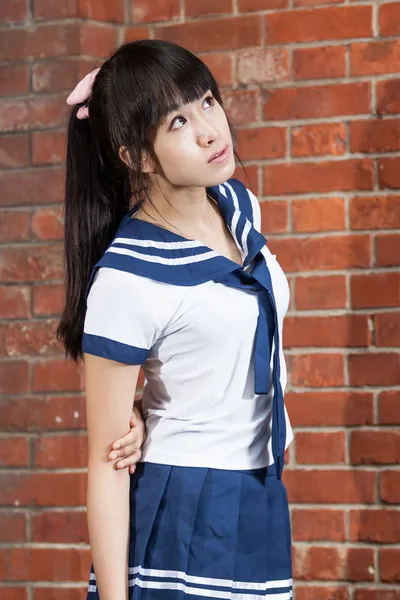 Asian schoolgirl in uniform outside school