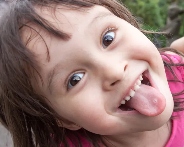 Young girl sticking out tongue while making funny face