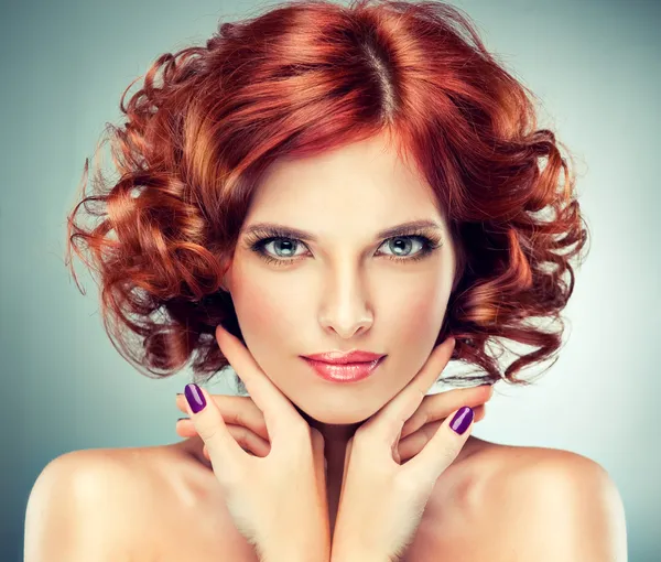 Redhead woman with bright makeup and manicure