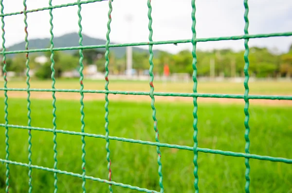 Wire fence closeup on soccer field background