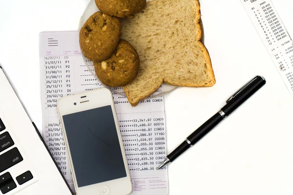 White work desk with a laptop computer, book bank, bread cup of