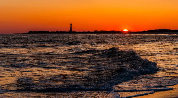 The Cape May Point Lighthouse and waves on the Atlantic at sunse