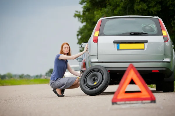 Driver fixing flat tire