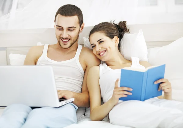 Young couple reading a book in bedroom