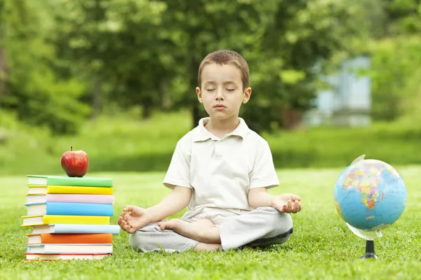 Beautiful child in zen meditation in park