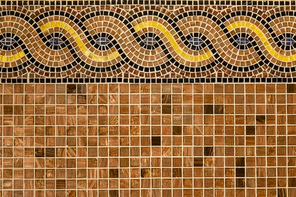 Mosaic in ancient style stacked with tiny brown, yellow, blue tiles.