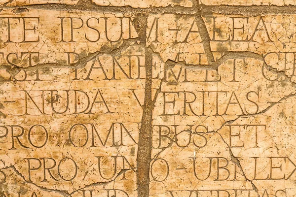 Cracked plaque with Latin inscriptions and Roman letters.