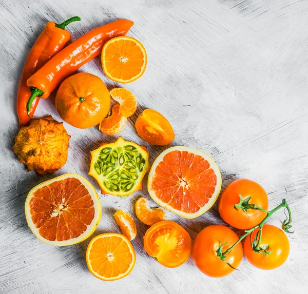 Orange fruits and vegetables on rustic background