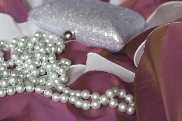 Clutch handbag and pearl necklace