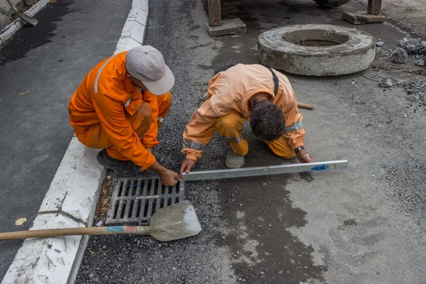 Workers on a road construction set out the string lines and leve