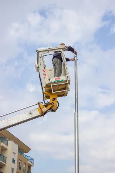 Worker on top of a pole fixing the supply 2