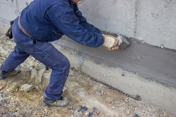 Construction worker with brush applied hydro insulation 2