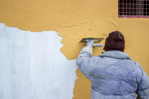Builder worker plastering facade 2