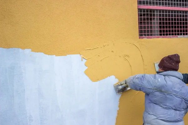 Builder worker plastering facade