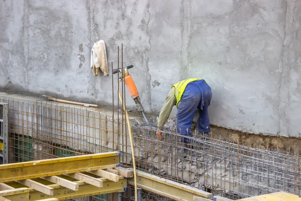 Builder worker cleaning after usingusing a jackhammer