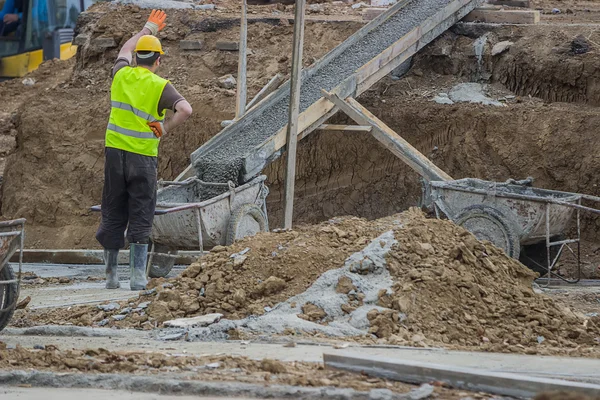 Builder worker pouring concrete in concrete trolley 2